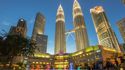 Kuala Lumpur Malaysia - July 31, 2016: Time lapse of beautiful and dramatic sunset day to night sky over Petronas Twin Towers, Suria KLCC. It is the most famous shopping mall in Kuala Lumpur. tilt up