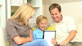 Attractive young family using a wireless tablet to talk to family and friends using online web chat