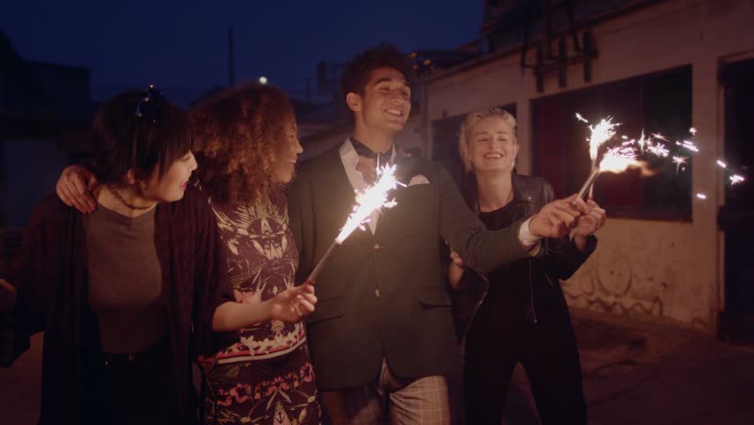 Happy young friends celebrating new years eve with sparklers at night. Best friends hanging out at night and celebrating outdoors.
 | Shutterstock HD Video #19109500