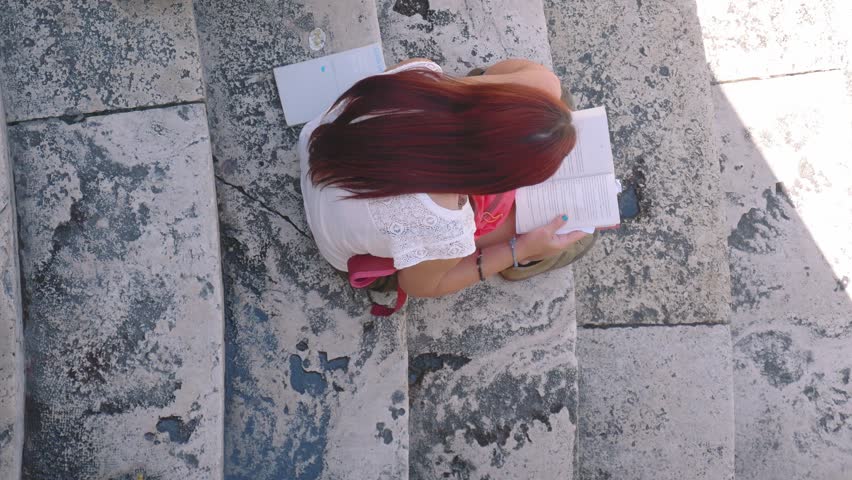 Girl reading a book on marble stairs, high angle shot | Shutterstock HD Video #19110664