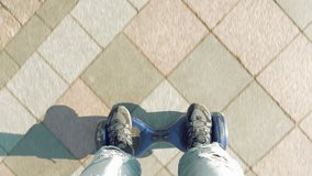 Man is riding hoverboard or electric self balancing gyro scooter board on the side walk. Modern and trendy urban transportation gadget. Popular youth city futuristic device. POV first person view. - Powered by Shutterstock - Get 15% off with code: PIKWIZARD15