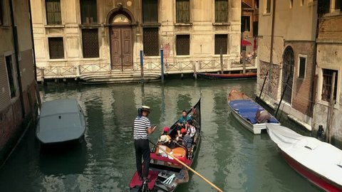 VENICE, ITALY - CIRCA 2016: 4K tourists enjoy gondola ride at narrow canel. Gondola is Venice world famous attraction. UHD stock video