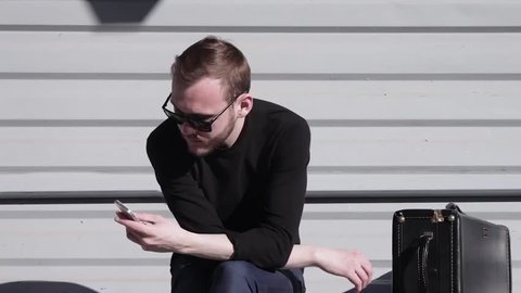 Cinemagraph - a Young Pretty Man is Typing on the Smartphone Froze Body Moves Hand Loop