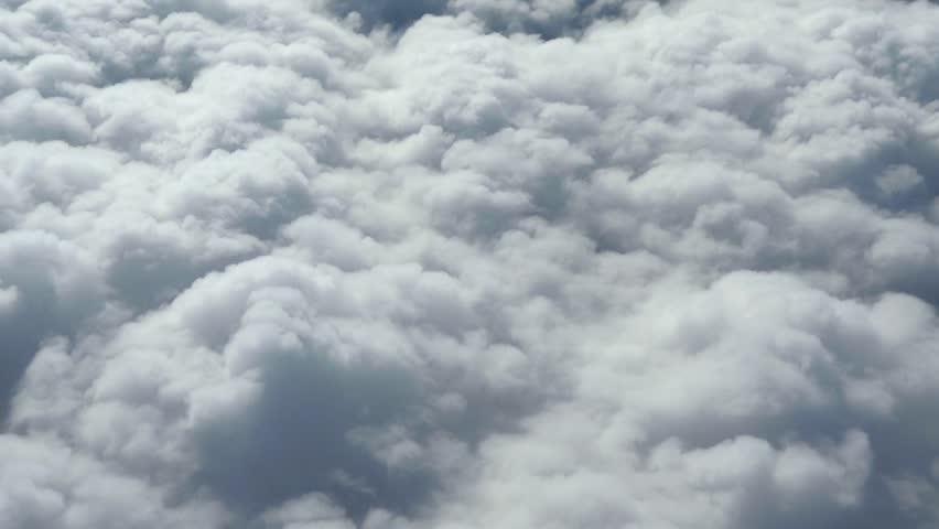 Airplane flying over clouds.Filmed from  commercial jet airplane window.