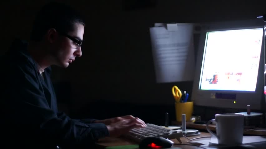Young man staying late in front of computer.
