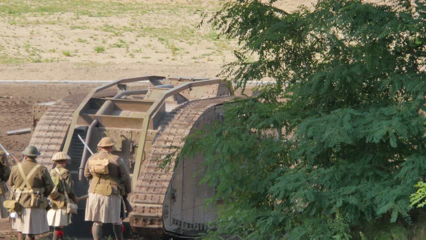 Military Tank with soldier walking behind