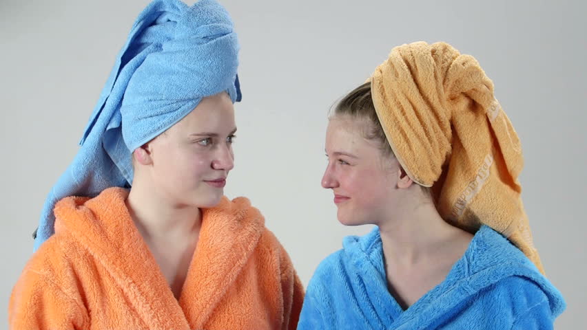 Teenage girls after shower applying cleansing skincare lotion for teens looking in mirror