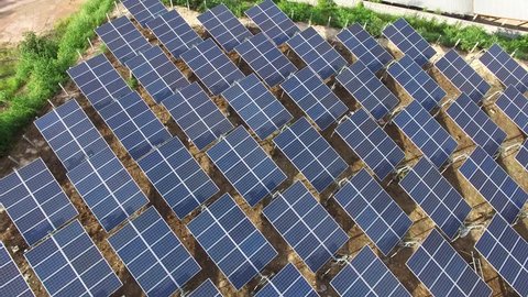 4K Aerial view of Industrial Solar Panels Farm (Electric power).Drone Flight Over Field Renewable Green Alternative Energy Concept in Thailand.