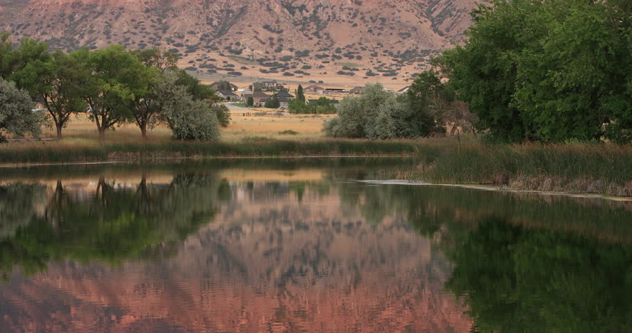 Beautiful reflection mountain on water of lake. Beautiful reflection of mountains, hills and sunset of calm water surface. Local swimming and fishing pond lake. Mount Nebo mountain valley. Warm days.