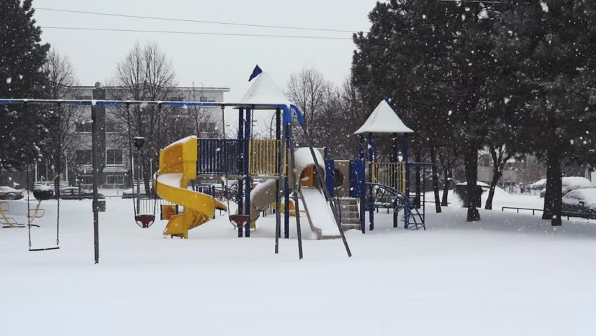 Playground during winter snowstorm.
