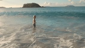 young boy playing in the waves at Cinnamon Bay, St John, United States Virgin Islands