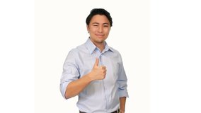 An attractive male in his 20s wearing a light blue shirt standing against a white background doing thumbs up.