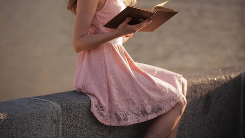 Beautiful girl on the waterfront with a book in their hands