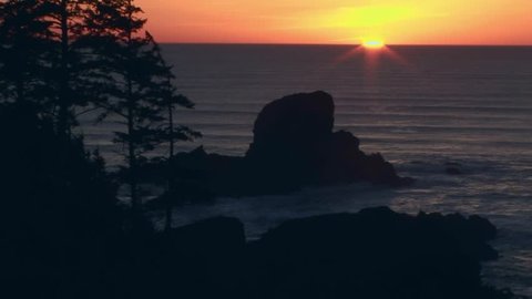 Red sunset with golden star disappearing into the Pacific ocean, Oregon - USA