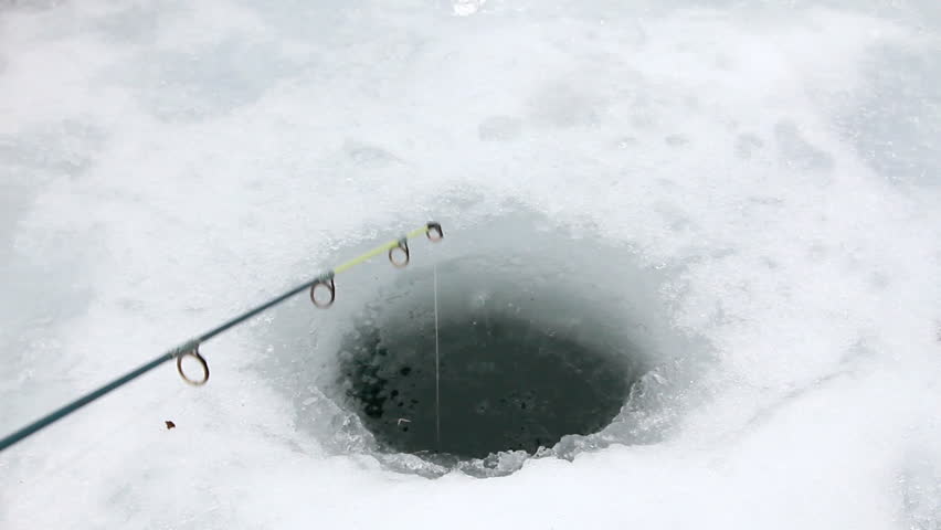 Hole drilled for ice fishing line dropped in