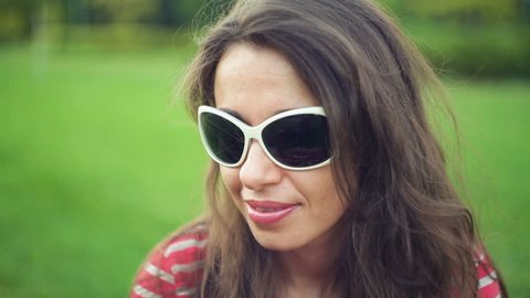 beautiful woman in sunglasses at the summer park