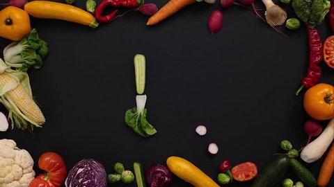 letter "N" laid out in vegetables. Tomatoes, cabbage, peppers and other vegetables on a black background. Vegetables are forming letters. Alphabet made of vegetables.