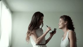 make-up artist and model in a large white studio