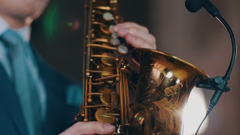 Saxophonist play on golden saxophone. Live performance. Jazz artist. Spotlights. Microphone
