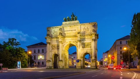 The Siegestor Victory Arch in Munich at dusk with traffic. Timelapse view in 4K.