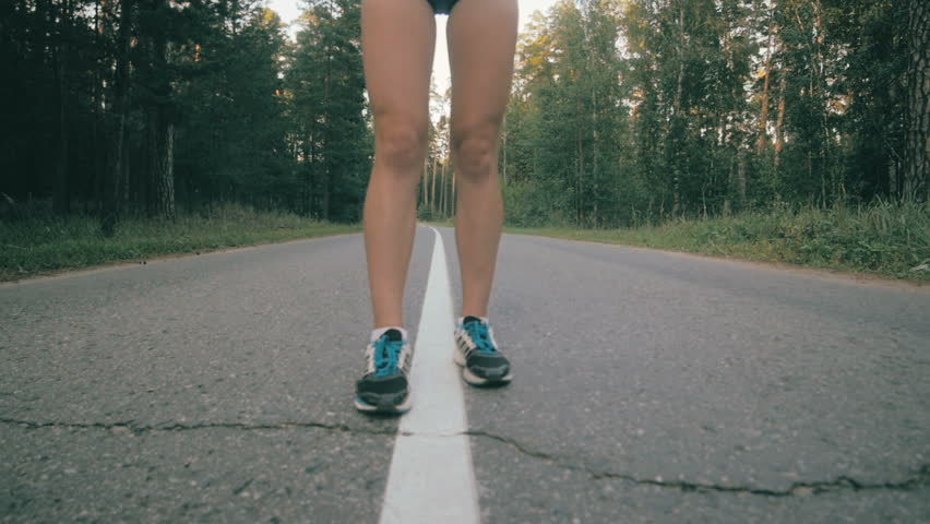 Athletic youg woman Jogging in a park. Stedycam shot.