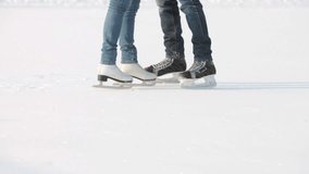 Tilt up of couple on skates kissing in winter park