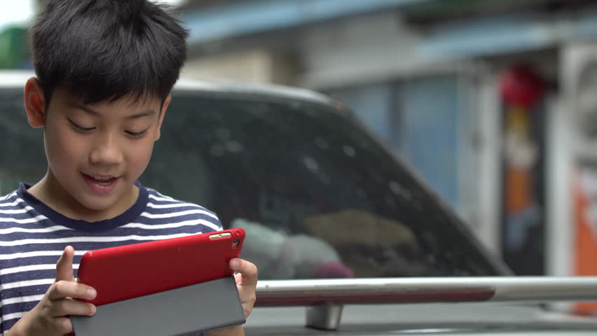 Asian boy using smart cell phone near the road ,Bangkok Thailand