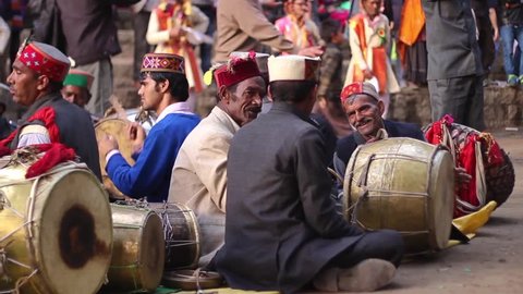 MANALI, H.P. INDIA - MAY 16, 2016- Traditional musicians play drums and horns during a religious festival, narrow depth of field, panning shot from drums to horns, in Manali, India