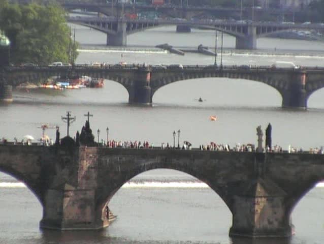 Long zoom of tourists crossing Charles Bridge Prague Czech Republic