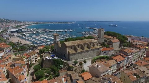 CANNES, FRANCE - JUL 28, 2016: Old quarter Le Suquet with Notre-Dame de lEsperance Church and tower of stronghold museum near Cannes Old Port Marina at summer day. Aerial view