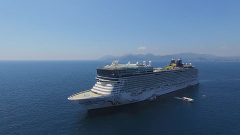 CANNES, FRANCE - JUL 28, 2016: Cruise liner Norwegian Epic with rescue boats sail not far from coastal city at summer sunny day. Aerial view