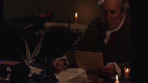 VIRGINIA - OCTOBER 2015 - Reenactment, Founding Fathers, American Revolutionary War era recreation -- Documents, Tabletop, quill writing, dipping ink and writing by candle light & by window, papers.