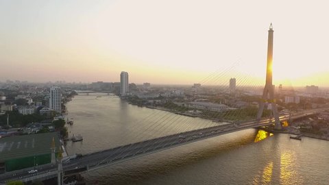 Drone Shot Rama 8 bridge crossing chaopraya river in heart of bangkok thailand capital important traveling destination , Sunet time.
