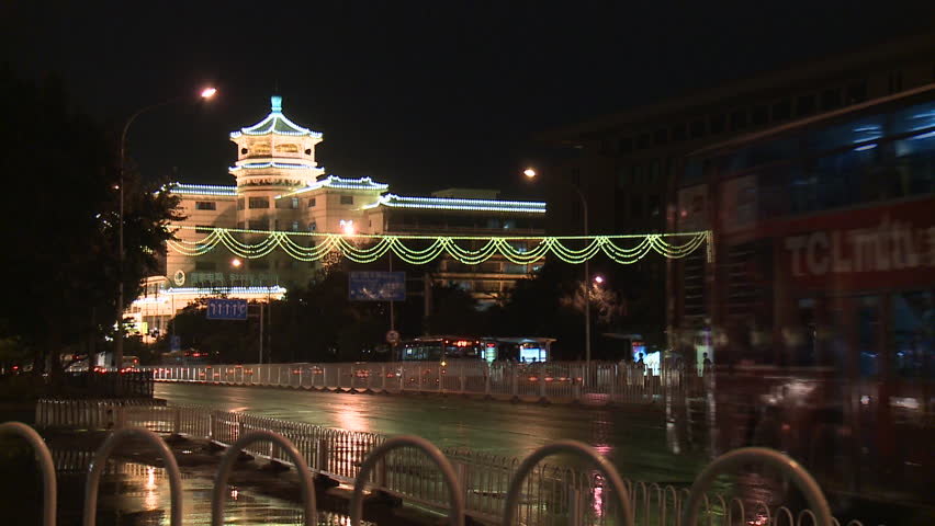 Tram in a street of Night Beijing. Traffic movement of vehicles car bus and people from the blazing lanterns streets in China.