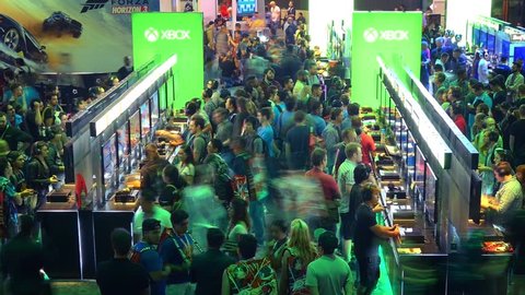 LOS ANGELES - June 16, 2016: Pan across crowds of gamers playing games in Microsoft XBOX booth at E3 2016 expo in Convention Center. E3 is an annual trade fair for the video game industry. Timelapse.