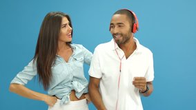 Happy multiracial couple with headphones sharing music and having fun together