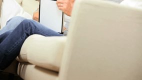 Retired caucasian couple using online internet webchat on wireless tablet to keep in touch with family