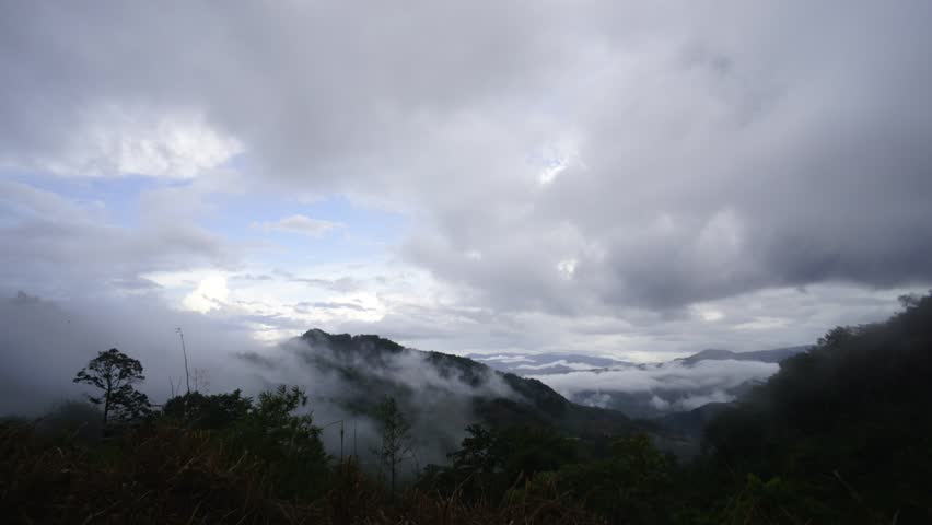 Time lapse of dramatic cloudy sky with rolling white mist over hilly landscape valley of beautiful Sabah Malaysian Borneo.