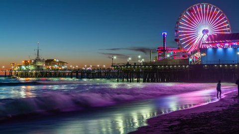 View of the Santa Monica Pier in Los Angeles at sunset. Timelapse. California, United States. Beautiful sunset in Santa Monica beach with the amusement park in the background. 