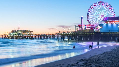 View of Santa Monica Pier in Los Angeles at sunset. Timelapse. California, United States. Beautiful sunset in Santa Monica beach with the amusement park in the background. 