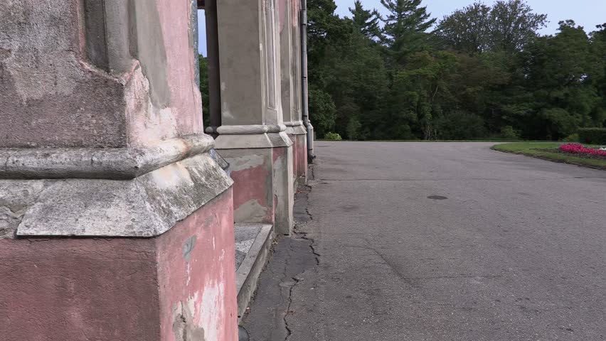 Man with folder talking on smartphone and walk near old building

