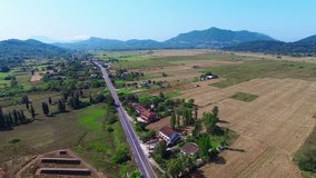 Flying over village countryside Greece. Aerial HD video. Farm, agriculture fields, road and houses 