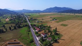 Countryside landscape 4k video. Aerial view of Greece ECO village, houses, fields, farm, road and mountain in background