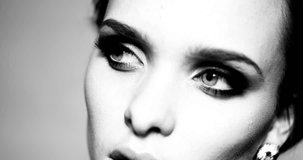 4k video portrait of pretty brunette woman with blue eyes and smokey makeup in black and white