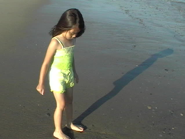 little asian girl chasing waves