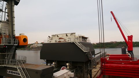 Crane discharging wood cheeps at port of Stockholm Sweden May 2016