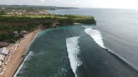 Shooting from flying drone of a resort for rich life with luxury villas and houses on Bali near sea with waves for surfing. Video with high quality resolution for presentation your advertising on TV 
