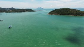 Shooting from flying drone of a beautiful sea with calm waves, excursion boats, wild islands with green plants and yacht parking near. Video with high quality resolution for presentation of display