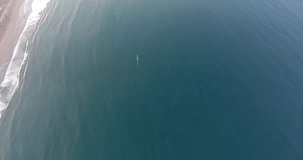 Top view aerial shooting from flying drone of a motorboat riding in sea near beach with luxury hotels and leased villas in Thailand. Video with  high quality resolution for your presentation on TV