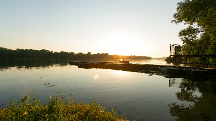 time lapse of mooring for boats at sunset, sunset on the river with pier for boats, People embarkation on jetty and transportation at sunset, boats docked at sunset on the river